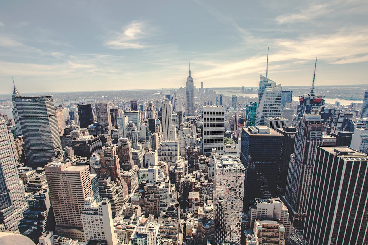Aerial view of the iconic New York City skyline showcasing skyscrapers under a clear blue sky.