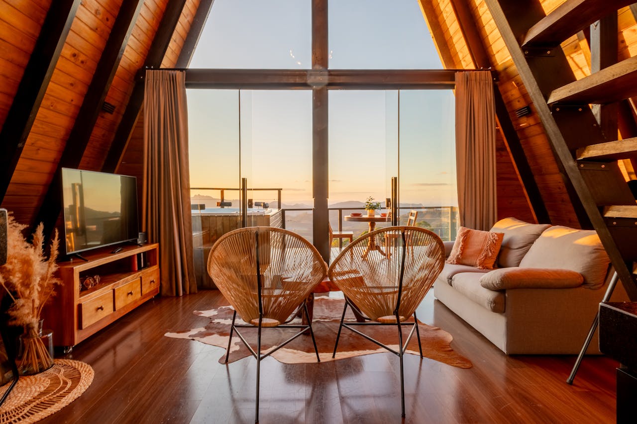 A warm and luxurious A-frame living room with modern decor, overlooking breathtaking mountain views.