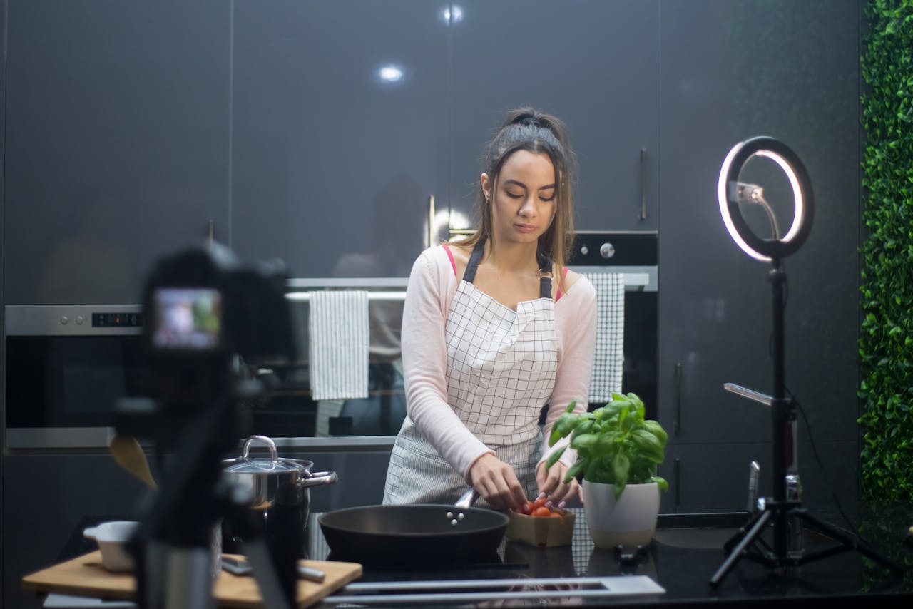 A young woman preparing a meal in a modern kitchen, filmed under professional lighting.